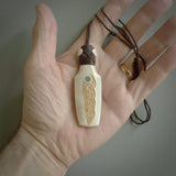 Hand carved engraved bone toki necklace hand made here in New Zealand. One only artistic toki pendant with hand plaited dark brown adjustable cord. Shipped to you with Express Courier. Stand out toki pendant for men and women. Bone Toki with engraved spiral on the back and paua shell insert on the front.