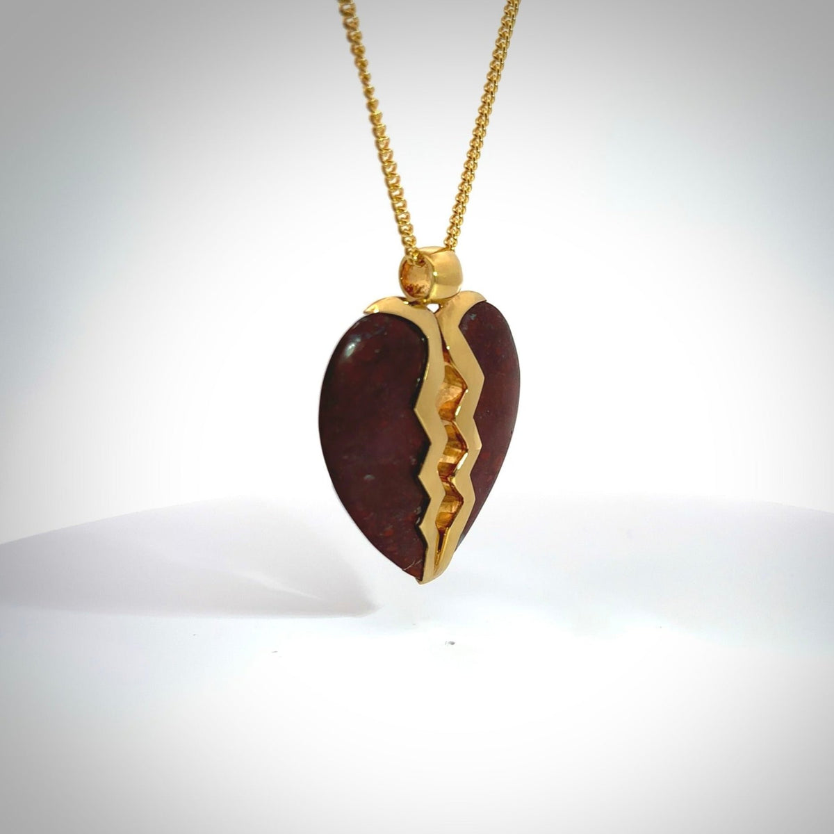This is a handcarved love heart pendant made from a gorgeous and striking piece of red jasper stone with gold plated silver. This is a superbly carved and very unique piece if custom jewellery. For sale online from NZ Pacific.