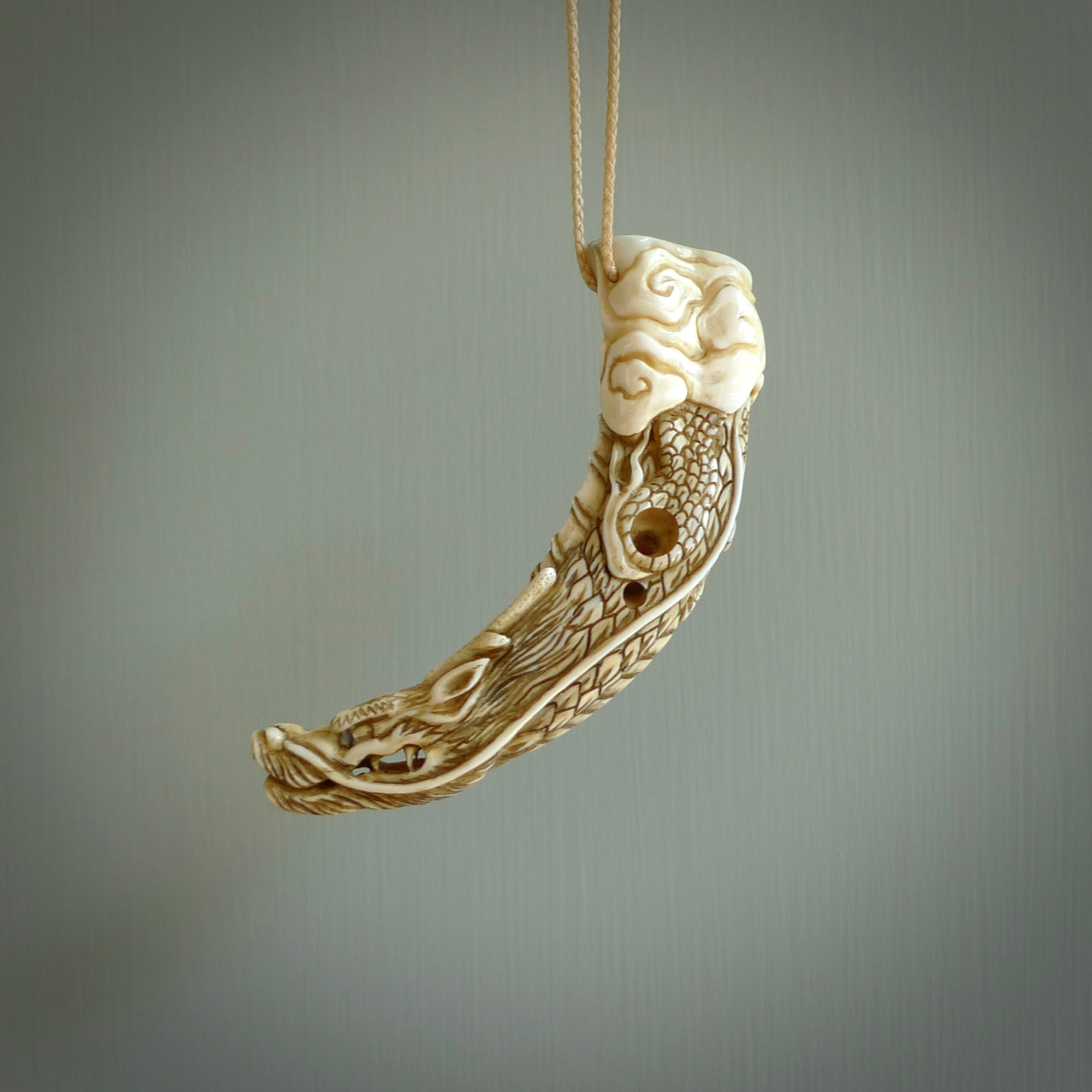 Hand carved dragon Pendant. Made from warthog tusk in New Zealand. Unique dragon necklace hand made from warthog tusk by master bone carver Fumio Noguchi. Spectacular collectable work of art, made to wear. One only pendant, delivered to you at no extra cost with express courier.