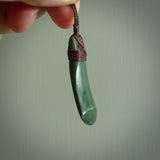 Hand carved from a lovely piece of local New Zealand Jade. The quality of the workmanship and design is outstanding - this is a piece you will want to wear all the time. We have suspended this from a 3-plait brown cord which can be adjusted with a couple of slip knots and brown binding.