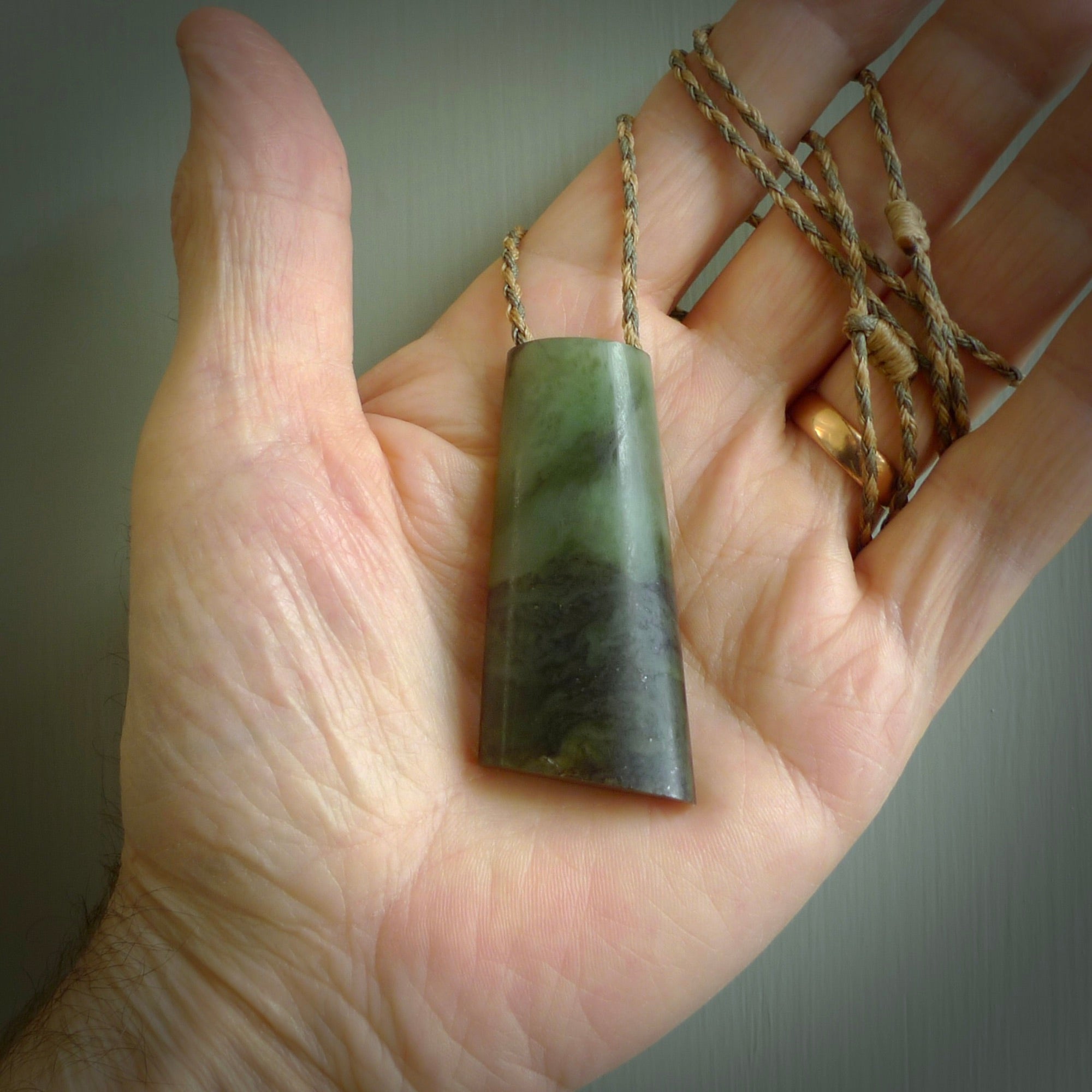 This photo shows a medium sized jade drop shaped pendant. It a a lovely, colourful douglas creek jade. The cord is a tan/green and is adjustable in length. One only large, contemporary drop necklace from Jade, by Rueben Tipene.