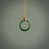 This piece is a oval round, ring pendant. It was carved for us by Ric Moor from a lovely light and milky green piece of New Zealand jade. It is suspended on a beige coloured braided cord that is length adjustable.