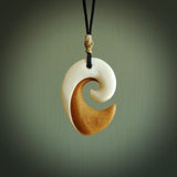 A hand carved bone contemporary, koru pendant. The cord is black colour and is adjustable. A medium sized hand made contemporary koru necklace by New Zealand artist Tonijae Brockway. Tonijae has stained parts of the bone which really add to the dimension of this pendant. One off work of art to wear.