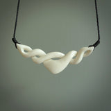 A hand carved twist pendant made from bone. This is a work of art carved by Fumio Noguchi who is renowned for his skill in bone carving. We deliver this pendant to you on a plaited black cord. Delivery with Express Courier is included in the price.