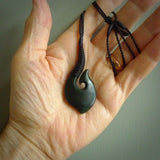 This picture shows a large deep green large jade hook pendant, also called a hei-matau, carved for us in New Zealand jade. The carver is Donna Summers - and this is a beautiful example of his work. The cord is a four-plait, adjustable black coloured necklace.