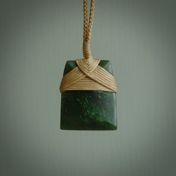 Hand carved from a lovely piece of local New Zealand Jade. The quality of the workmanship and design is outstanding - this is a piece you will want to wear all the time. We have suspended this from a 3-plait tan cord which can be adjusted with a couple of slip knots and tan binding.