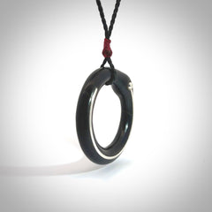 This picture shows a hand carved black jade circle pendant with sterling silver inlay. It is suspended from an adjustable Black cord. Delivery is free worldwide.