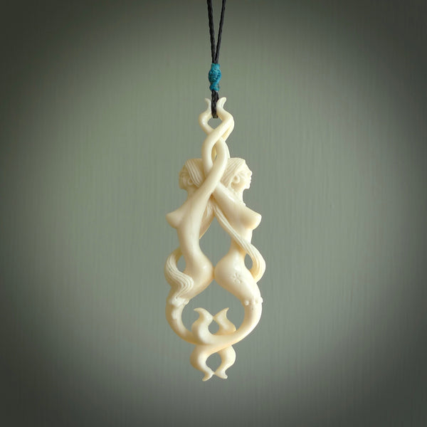 A hand carved bone double mermaid pendant. This is a work of art carved by Yuri Terenyi who is renowned for his skill in bone carving. Art to wear for lovers of collectable art. Delivered with Express Courier. Provided on a black adjustable cord.