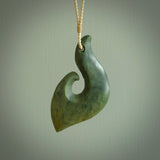 This matau, is a large pendant hand carved from New Zealand jade. It is both intricate and contemporary in design - it has hidden folds and smooth curves. A piece to be worn, the carving and the jade are both magnificent. A large hand carved New Zealand Jade hook by artist Ric Moor.