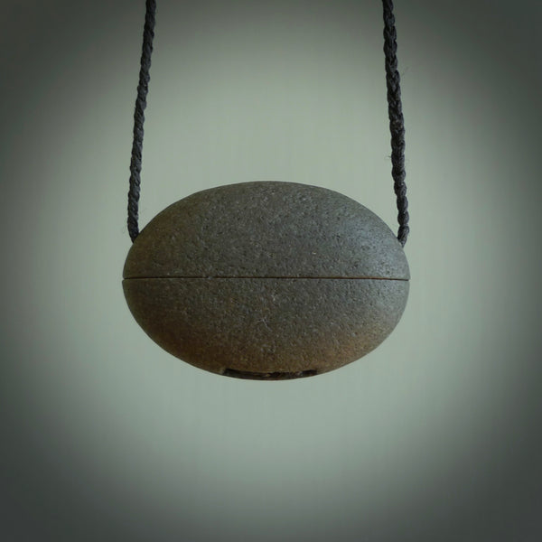 Greywacke stone pendant with New Zealand Inanga Pounamu insert. Hand carved by Rhys Hall for NZ Pacific. Handmade contemporary jewellery for sale online.