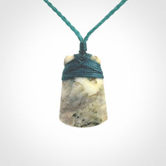 This is a handcrafted aotea stone Toki pendant.