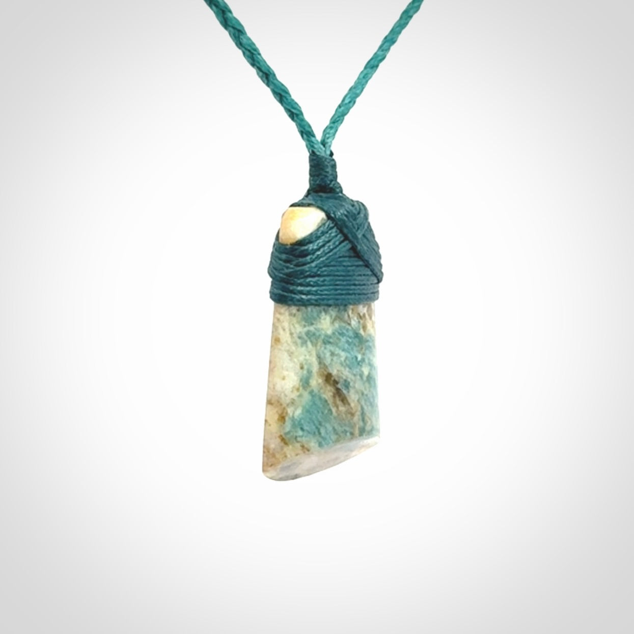 This is a handcrafted aotea stone Toki pendant.