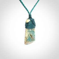 This is a handcrafted aotea stone Toki pendant.