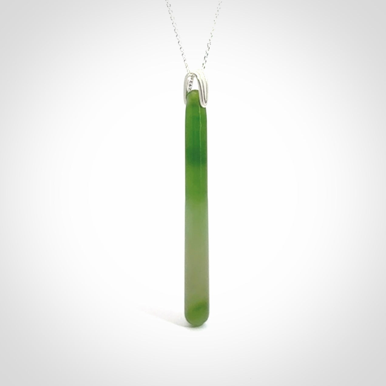 A hand carved New Zealand Jade Drop pendant with sterling silver clasp and chain.