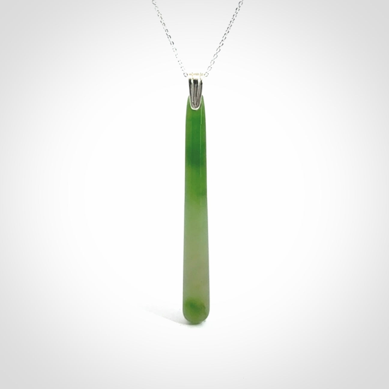 A hand carved New Zealand Jade Drop pendant with sterling silver clasp and chain.