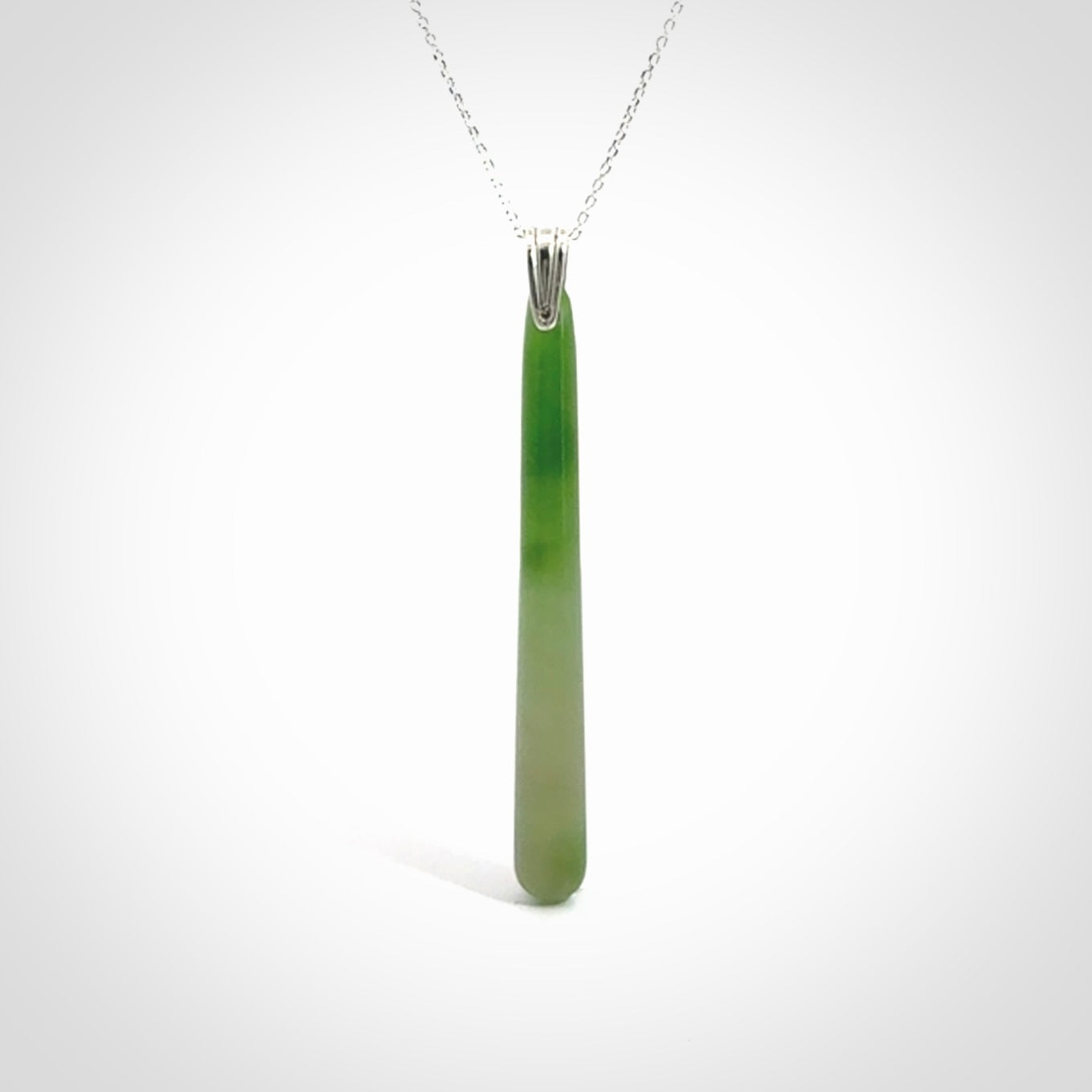 A hand carved New Zealand Jade Drop pendant with sterling silver clasp and chain.