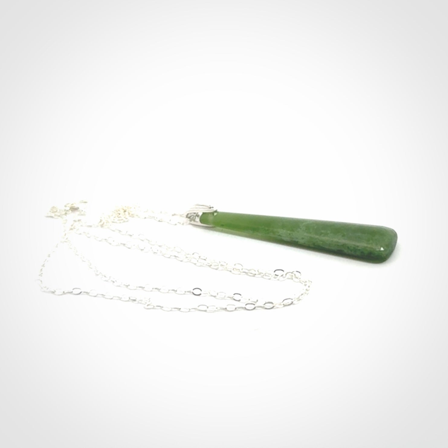 A hand carved New Zealand Jade Drop pendant with sterling silver clasp and chain.