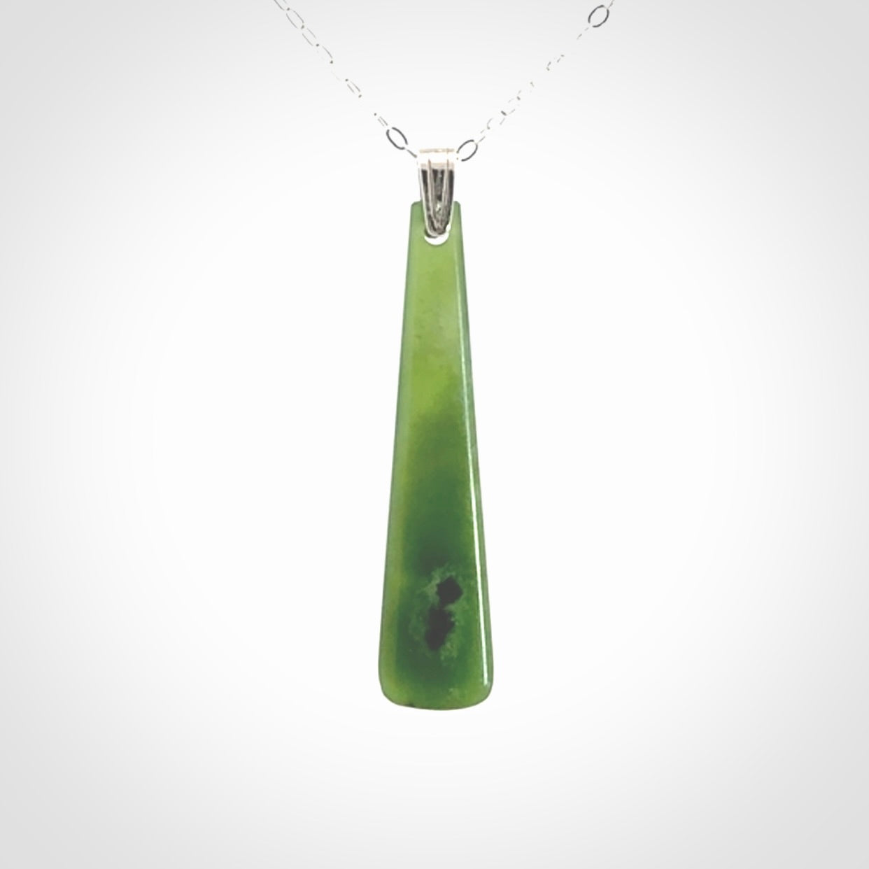A hand carved New Zealand Jade Drop pendant with sterling silver clasp and chain.