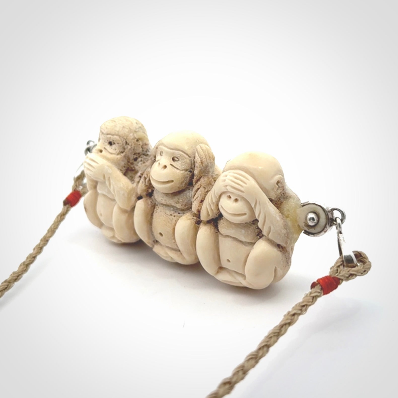 This is a hand carved deer antler three wise monkeys pendant. It is made from deer antler, bone. This is a large sized necklace and is a very unique, one only, pendant that has an adjustable tan cord. Hand carved deer antler three wise monkeys necklace for men and women. Hear, Speak, See no evil monkey pendant.