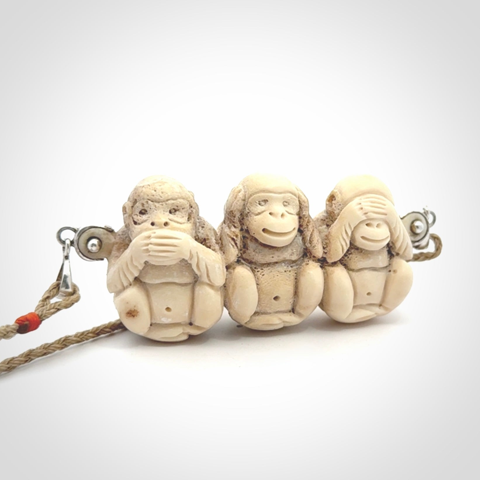This is a hand carved deer antler three wise monkeys pendant. It is made from deer antler, bone. This is a large sized necklace and is a very unique, one only, pendant that has an adjustable tan cord. Hand carved deer antler three wise monkeys necklace for men and women. Hear, Speak, See no evil monkey pendant.