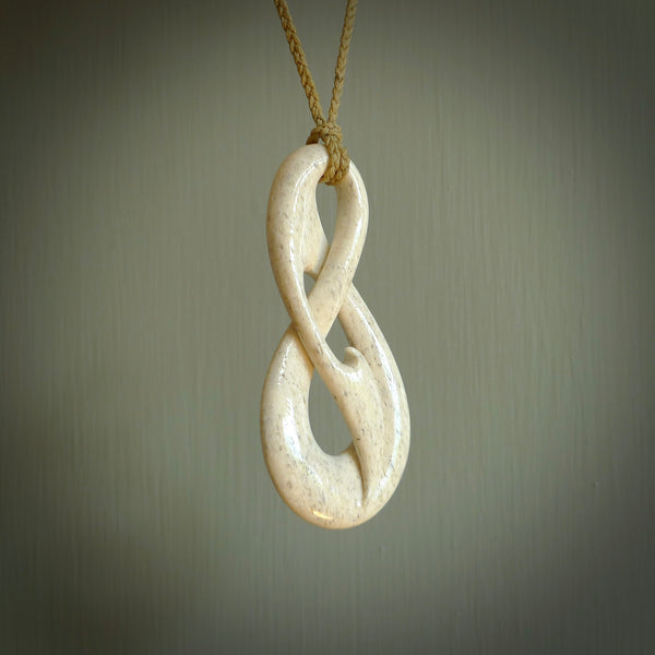 A hand carved intricate and complex woven design pendant from Whale Bone. The cord is tan and adjustable in length. Large hand made woven necklace by New Zealand artist Kerry Thompson.