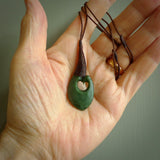 This picture shows a large deep green large jade hook pendant, also called a hei-matau, carved for us in New Zealand jade. The carver is Donna Summers - and this is a beautiful example of his work. The cord is a four-plait, adjustable brown coloured necklace.