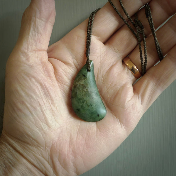 This photo shows a large jade drop shaped pendant. It a a lovely deep green jade. The cord is a four plait olive green and is adjustable in length. One only medium, contemporary drop necklace from Jade, by Ric Moor.