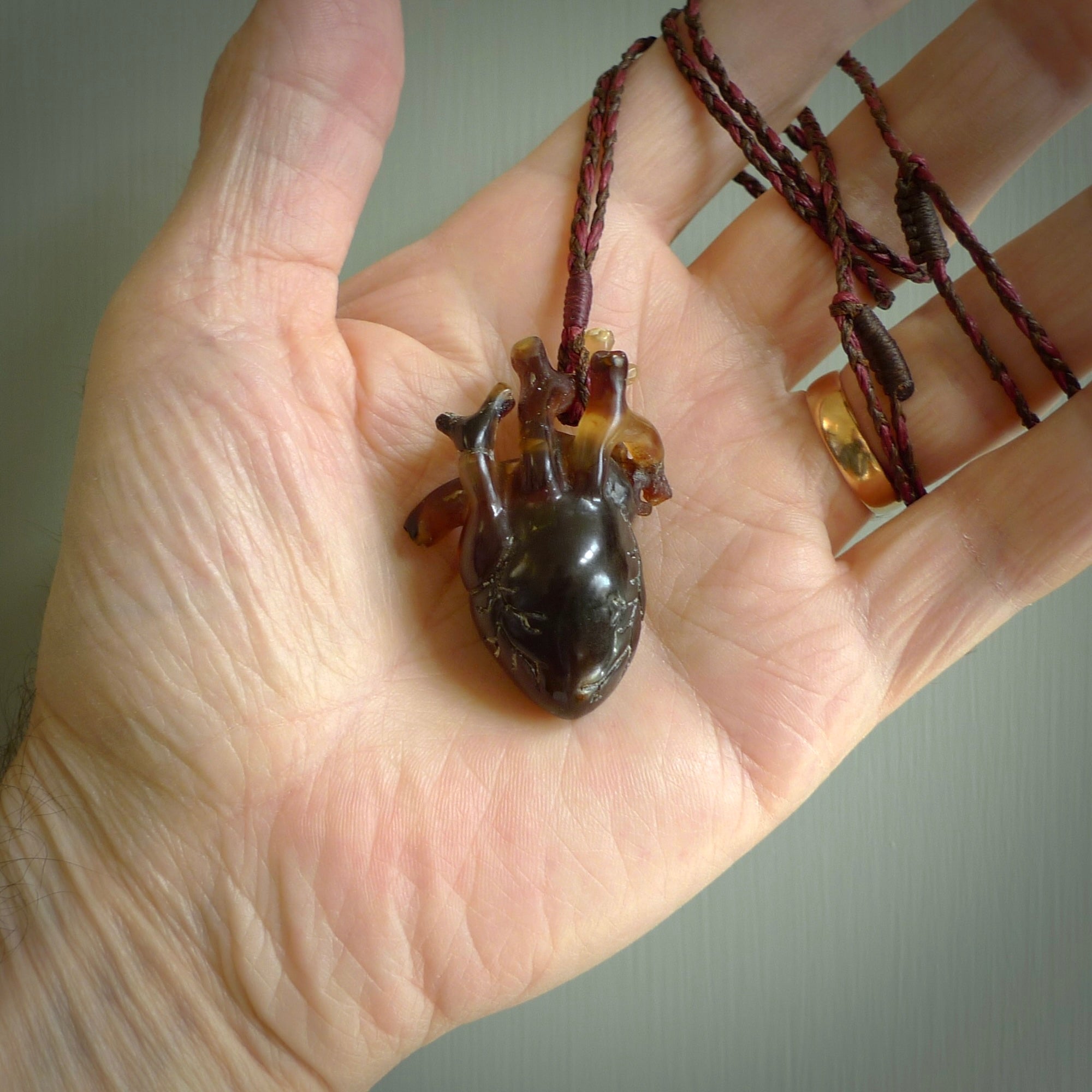 This pendant is handcrafted from rare Amber. It replicates a human heart. It is supplied with an adjustable tan cord. It is a graceful and very interesting piece that will attract admiration and comment. Free Express Shipping.