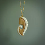 A hand carved bone contemporary, intricate pendant. The cord is ice white and burnt gold and is an adjustable length. A large sized hand made contemporary necklace by New Zealand artist Kerry Thompson. Kerry has stained parts of the bone which really add to the dimension of this pendant. One off work of art to wear.