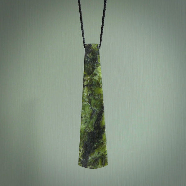 This photo shows a large jade drop shaped pendant. It a a lovely, colourful douglas creek jade. The cord is a four plait black and is adjustable in length. One only large, contemporary drop necklace from Jade, by Rueben Tipene.