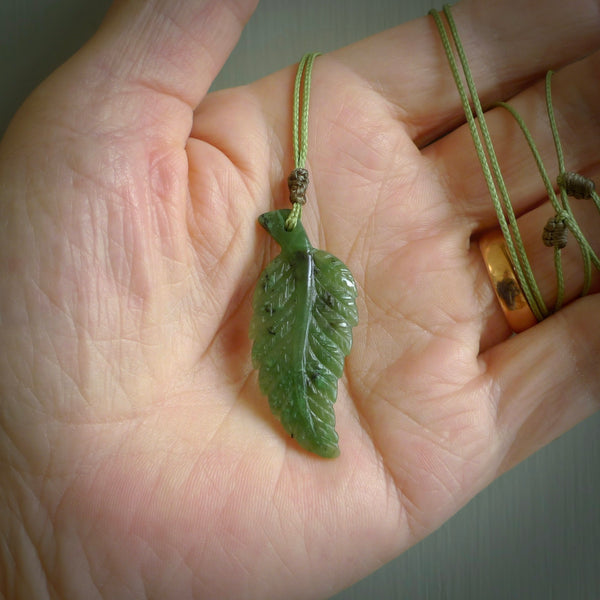 A delicate green jade fern leaf pendant with an adjustable neck cord. Green stone fern leaf necklace with adjustable cord. Delivery included.