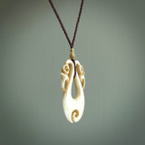 This is a unique double manaia with koru, hand carved stained bone pendant with. The bone is a brown honey colour which has been stained using a homemade dye. The cord is Black and is length adjustable. This is delivered to you with Express Courier.