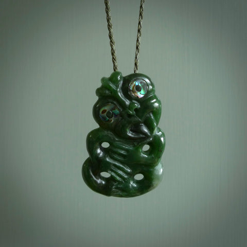 This is a medium sized tiki - carved from gorgeous Marsden jade. The craftsmanship is superb, this piece is as well carved as any we have seen. The cord is an adjustable plaited cord in black.