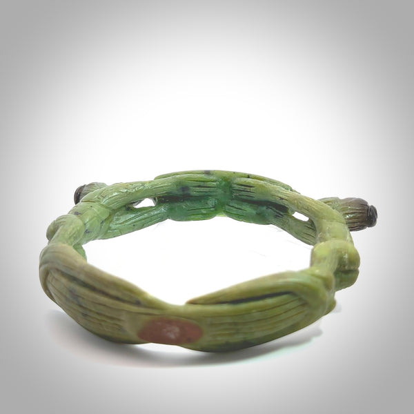 A photo of a New Zealand Jade bangle. This is a one off, statement piece - hand crafted here in New Zealand by Jeromy. Unique Art to Wear. Gifts for all lovers of hand made Art to Wear. One only collectors pendant. Delivery is free worldwide.
