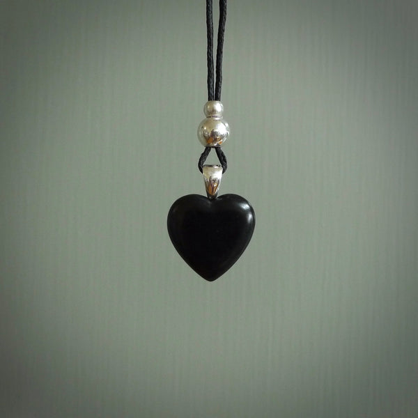 Hand carved heart pendant made in black jade and bone. Made by NZ Pacific. Carved from black jade and bone. Free delivery worldwide.