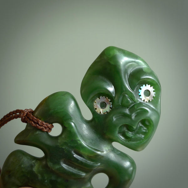 This is a large sized tiki - carved from gorgeous Marsden jade with Pāua Shell eyes. The craftsmanship is superb, this piece is as well carved as any we have seen. We have plaited an adjustable brown cord for this piece. 