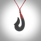 This piece is a hand carved black jade matau pendant, otherwise known as a traditional fish hook necklace. This piece has been carved by us and is made from a wonderful lustrous black jade that we source in Australia. It is a striking traditional piece which we hand bind with a Brown/Flax coloured cord. Delivery is free worldwide.