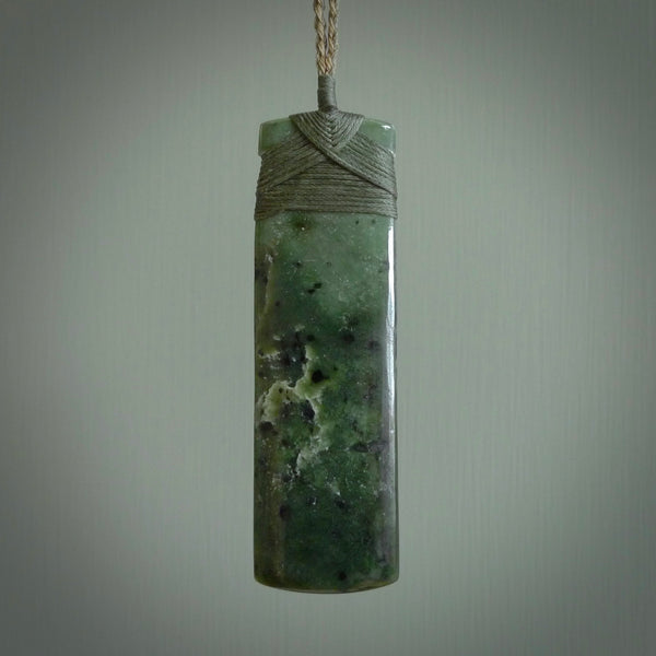 A large and beautiful hand carved toki pendant. This piece is carved from New Zealand flower jade by NZ Pacific. This is a wonderful large toki bound with a hand-plaited cord and a traditional lashing. A beautiful, traditional toki for sale online.
