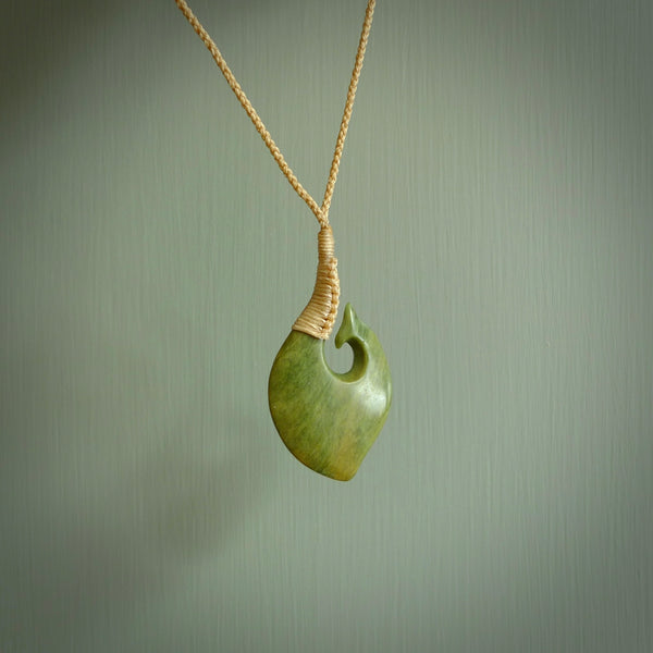 This matau, is carved from a very striking New Zealand jade. It is both intricate and simple in design - it has hidden folds and smooth curves. A piece to be worn or displayed - the carving and the jade are both magnificent. Hand made by Donna Summers.