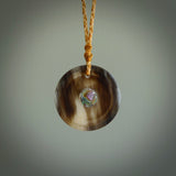 Hand carved natural bone with buffalo horn contemporary disc pendant with creative and unique carvings on the front face of each individual piece. Delivered with an adjustable cord.