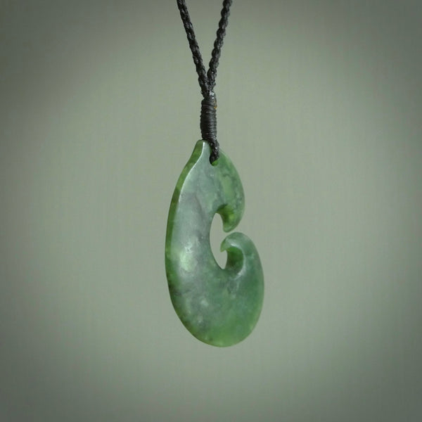 This photo shows a traditional hook pendant. It a a lovely deep green jade. The cord is a four plait black and is adjustable in length. One only, contemporary matau necklace from Jade, by Ric Moor.