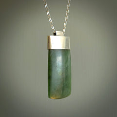 This picture shows a hand carved jade toki, drop pendant with sterling silver cap and chain. The jade is a very dark green with a shimmer in the stone. It is suspended from a sterling silver clasp and we supply a sterling silver chain. Delivery is free worldwide.