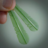 This picture shows New Zealand Pounamu, jade feather earrings with sterling silver hooks. Hand made unique and contemporary feather earrings by Kerry Thompson. Hand carved here in New Zealand from New Zealand Jade. One pair only.