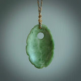 This picture shows a contemporary drop shaped pendant, hand carved from New Zealand flower jade. We will provide this with an adjustable plaited cord. Hand crafted stunning New Zealand Marsden Flower Jade drop pendant by Ana Krakosky.