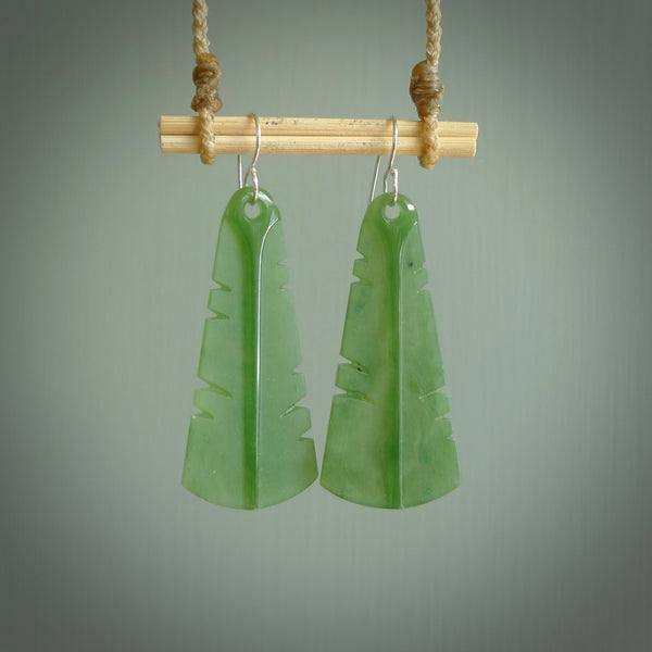 This picture shows New Zealand Pounamu, jade feather earrings with sterling silver hooks. Hand made unique and contemporary feather earrings by Kerry Thompson. Hand carved here in New Zealand from New Zealand Jade. One pair only.