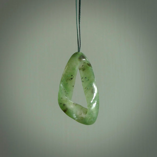 This little piece is a hand carved möbius ribbon pendant. We've carved this from Nephrite Jade from Aceh. It has very subtle colour variations in the stone and is a delightful, small and artistic piece of jewellery.