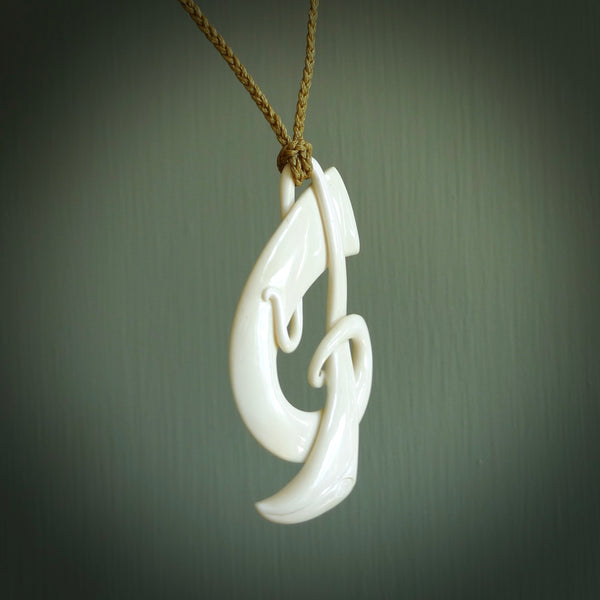 A hand carved bone contemporary, intricate Koru pendant. The cord is tan colour and is an adjustable length. A large sized hand made contemporary necklace by New Zealand artist Kerry Thompson. Kerry has carved this from Beef bone. One off work of art to wear.