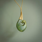 This matau, with koru, is carved from a very striking New Zealand jade. It is both intricate and simple in design - it has hidden folds and smooth curves. A piece to be worn or displayed - the carving and the jade are both magnificent. Hand made by Donna Summers.