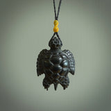 This picture shows a hand carved black jade turtle pendant. It is polished to a soft shine and has quite a lot of detail carved into the jade. The cord is a hand plaited black, waxed polyester. Carved by NZ Pacific.