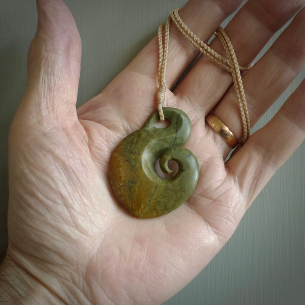 This koru, is carved from a very striking New Zealand flower jade. It is both intricate and simple in design - it has hidden folds and smooth curves. A piece to be worn or displayed - the carving and the jade are both magnificent.